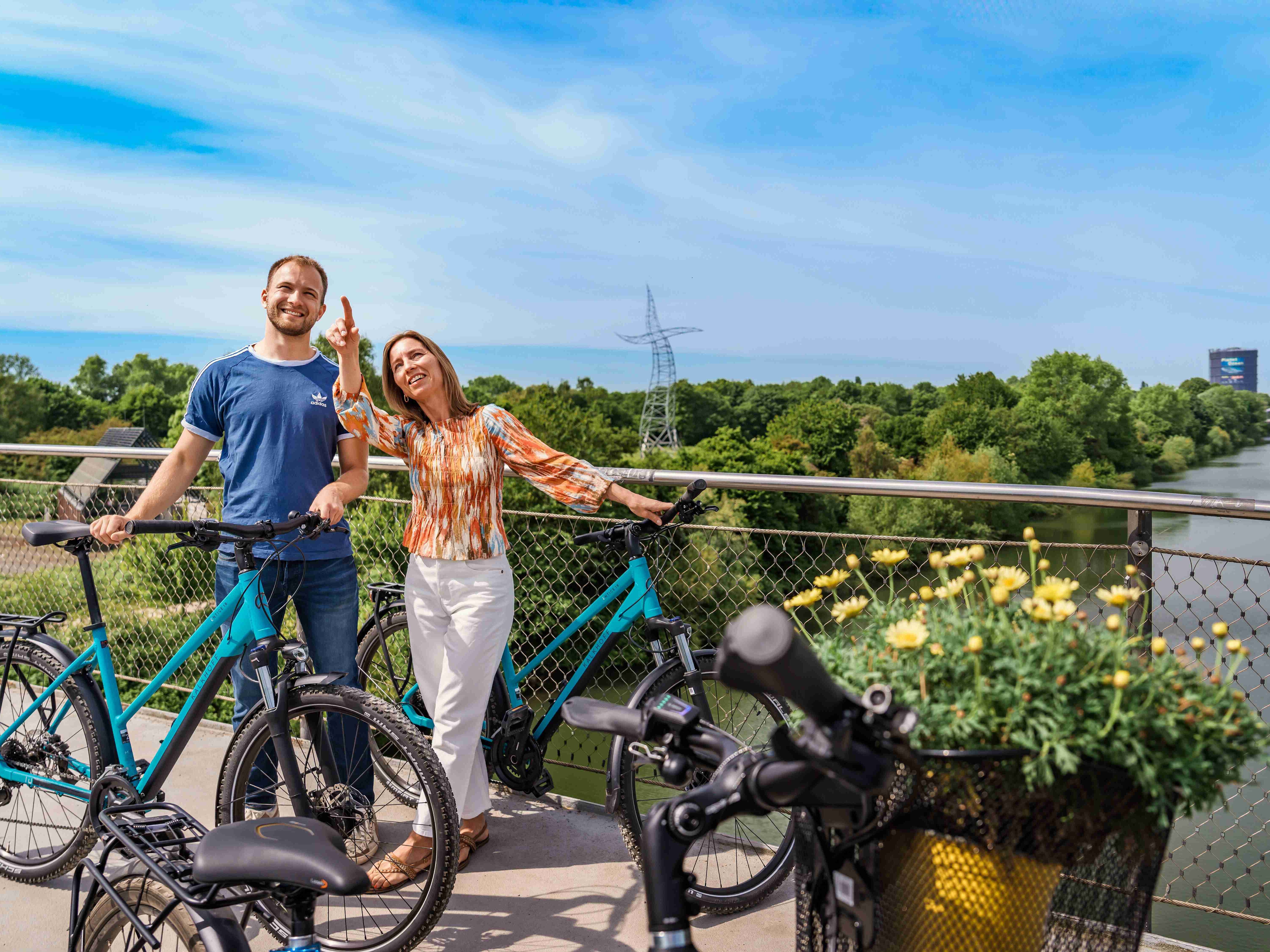 Zwei Personen stehen mit ihren Fahrrädern auf einer Brücke am Haus Ripshorst